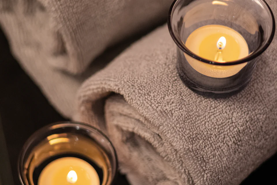 Rolled towels with two lit tealights