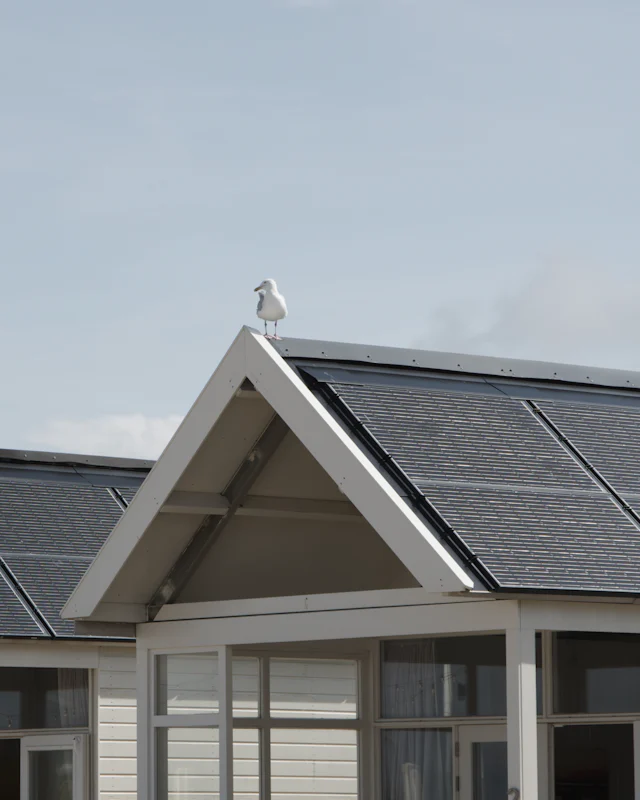 A white gable with dark solar panels laid flush over the roof