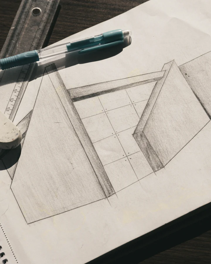 A pencil sketch of gabled forms on a sketchpad, with a ruler and an eraser