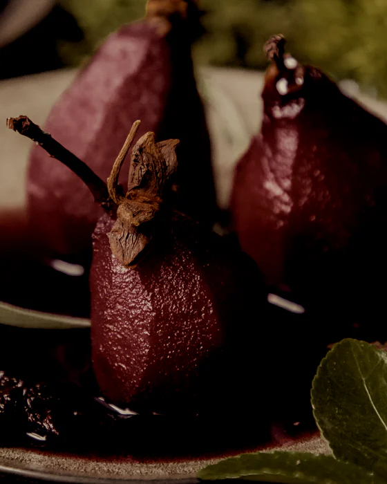 Pears poached in red wine on a pewter plate